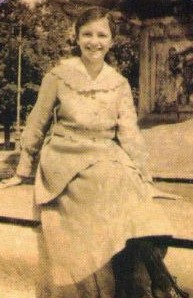 young woman sitting outside and smiling into the camera